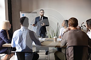 Confident businessman giving flip chart presentation at corporate meeting