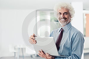 Confident businessman holding a laptop