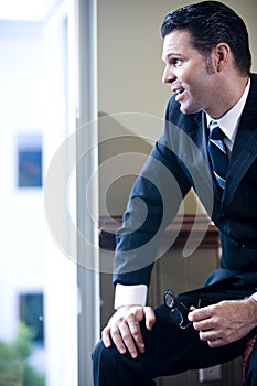 Confident businessman looking out office window