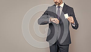 confident businessman man in suit showing debit card cheking time for copy space, fast payment