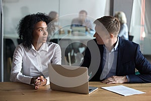 Confident businessman mentor giving instructions to trainee at workplace