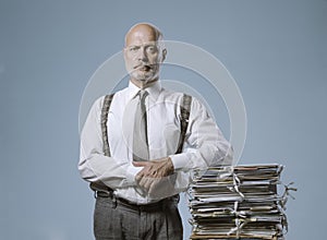 Confident businessman posing with a pile of paperwork