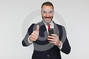 Confident businessman reading emails and making thumbs up gesture