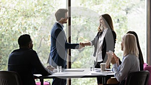 Confident businessman shake hand greeting female colleague