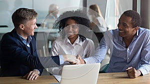 Confident businessman shaking hand of African American business partner