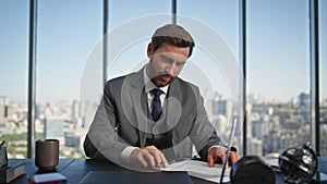 Confident businessman signing contract at desk. Smiling financial manager work