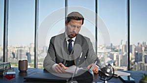 Confident businessman signing contract at desk. Smiling financial manager work