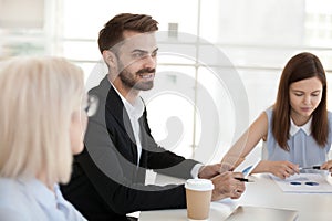 Confident businessman sit at table, discuss project at company meeting