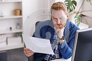 Businessman reading contracts while working in an office