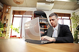 Confident businessman sitting with laptop