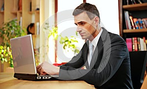 Confident businessman sitting with laptop