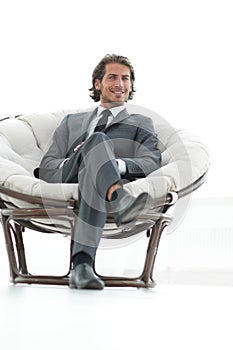 Confident businessman sitting in a large comfortable chair.