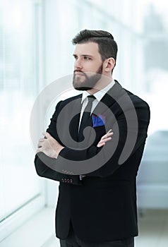 Confident businessman standing near the office window