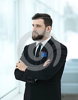 Confident businessman standing near the office window