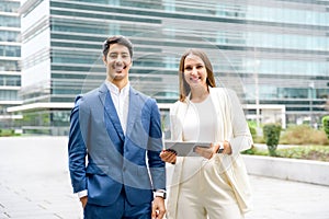 Confident businessman in suit and businesswoman using tablet together