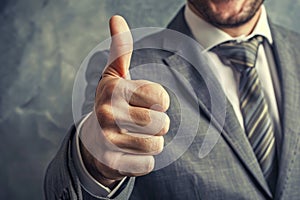 Confident businessman in a suit smiling and giving a thumbs up gesture, A businessman with a confident smile, giving a thumbs up