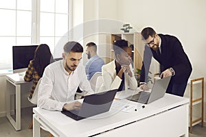 Confident businessman talking checking afro american employee report on laptop