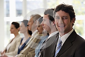 Confident businessman with team walking past him