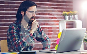 Confident businessman using laptop on desk