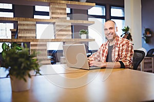 Confident businessman using laptop at desk