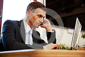 Confident businessman using laptop