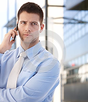 Confident businessman using mobile outdoors