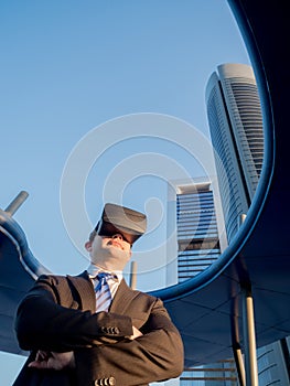 Confident businessman using virtual reality glasses in a business center