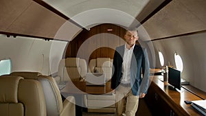 Confident businessman walking inside of private jet cabin