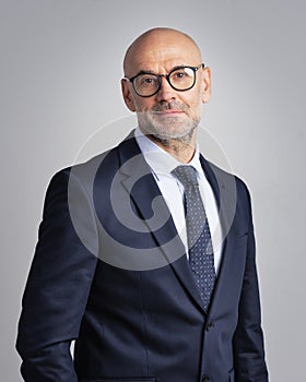 Confident businessman wearing suit and tie agains isolated background
