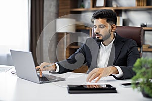 Confident businessman wearing suit writing notes or financial report