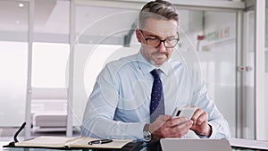 Confident businessman working on smartphone