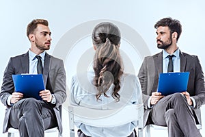 confident businessmen with clipboards looking at each other during