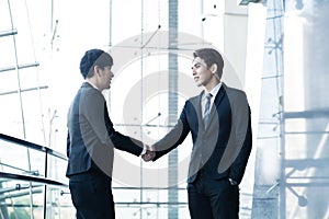 Confident businessmen shaking hands and smiling