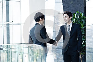 confident businessmen shaking hands and smiling