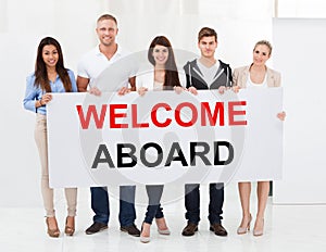 Group Of People Holding Welcome Aboard Placard photo