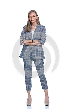 Confident businesswoman in blue checkered suit crossing arms