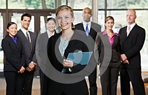 Confident businesswoman in front of co-workers