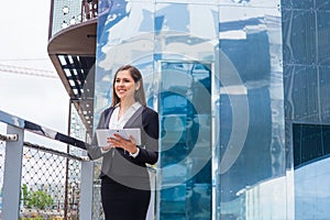 Confident businesswoman in front of modern office building. Business, banking, corporation and financial market concept.