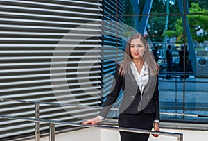 Confident businesswoman in front of modern office building. Business, banking, corporation and financial market concept.