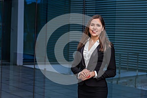 Confident businesswoman in front of modern office building. Business, banking, corporation and financial market concept.