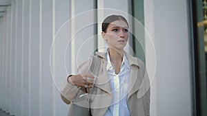 Confident businesswoman going work near modern building close up. Girl walking.