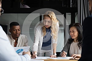 Confident businesswoman lead meeting with diverse colleagues in office