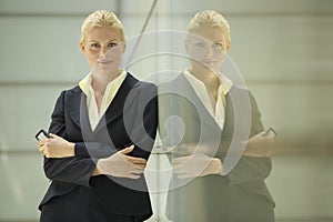 Confident Businesswoman Leaning Against Glass Partition