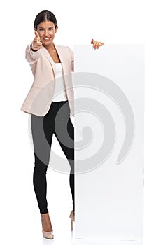 Confident businesswoman pointing fingers and holding empty board