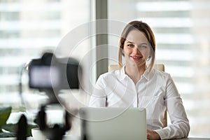 Confident businesswoman recording video course on camera