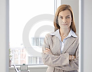Confident businesswoman smiling in bright office