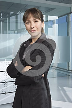 Confident Businesswoman Standing Arms Crossed In Office