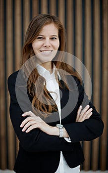 Confident businesswoman standing with her arms crossed. smiling and looking at the camera.