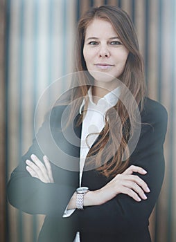 Confident businesswoman standing with her arms crossed. smiling and looking at the camera.