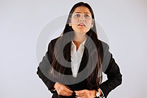 Confident businesswoman in a suit standing against a white background with an assertive expression
